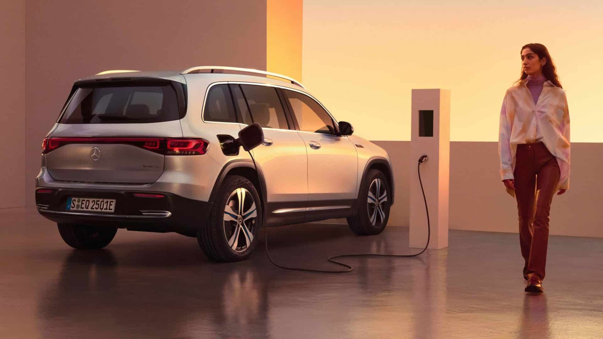 elektrisk suv som laddas och kvinna som går bredvid